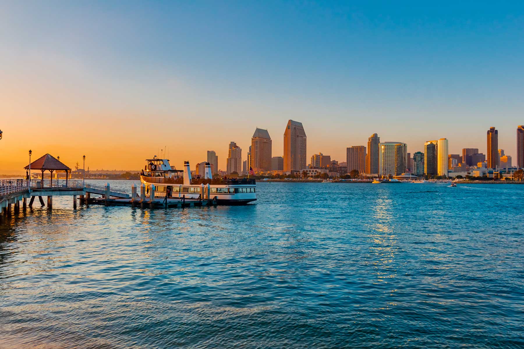 San Diego Bay at dusk with ferry at dock.